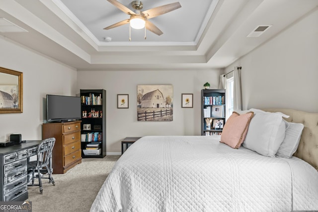bedroom featuring visible vents, a tray ceiling, carpet floors, and ceiling fan
