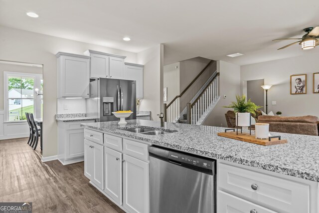 kitchen with white cabinets, dark wood finished floors, appliances with stainless steel finishes, and a ceiling fan