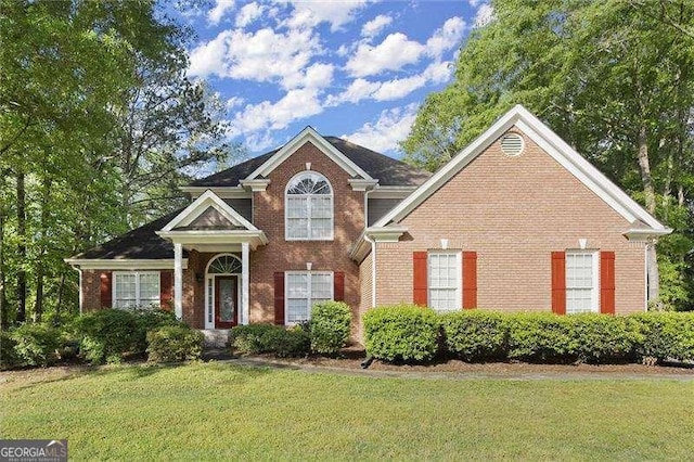 view of front of home with a front lawn and brick siding