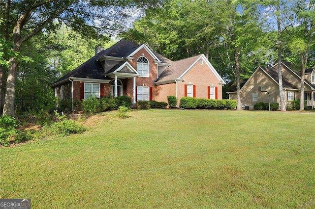 view of front of house featuring a front lawn and brick siding