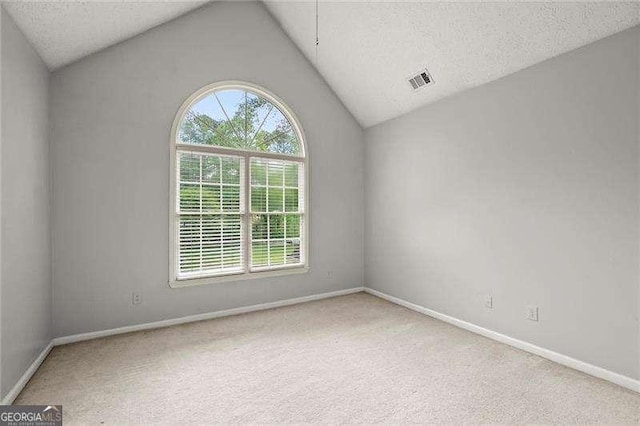 unfurnished room featuring baseboards, carpet flooring, vaulted ceiling, and visible vents