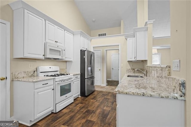 kitchen with visible vents, a sink, white cabinetry, and white appliances