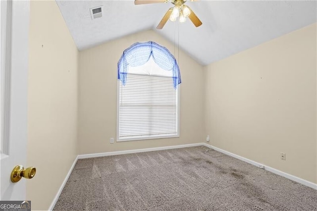 empty room featuring ceiling fan, carpet, baseboards, vaulted ceiling, and visible vents