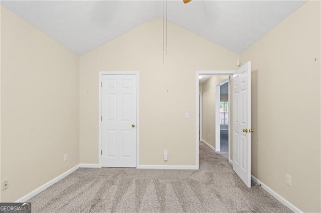 unfurnished bedroom with baseboards, carpet, and vaulted ceiling