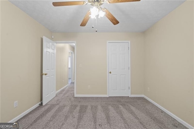 unfurnished bedroom featuring carpet floors, baseboards, and ceiling fan