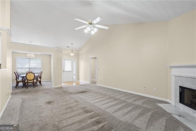 carpeted living area featuring baseboards, a ceiling fan, high vaulted ceiling, and a premium fireplace