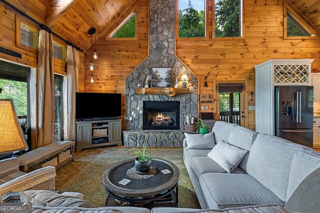 living room with a fireplace, wood walls, high vaulted ceiling, and wooden ceiling