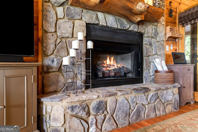 room details featuring a stone fireplace and wood finished floors