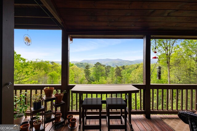 deck featuring a mountain view and a wooded view