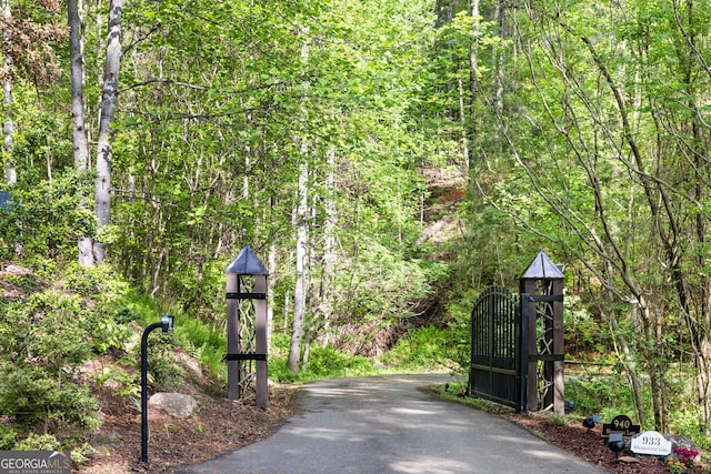 view of gate featuring a view of trees