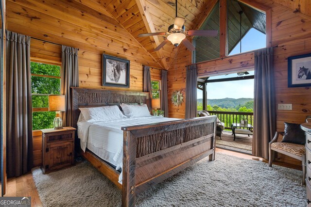 bedroom with wood walls and multiple windows