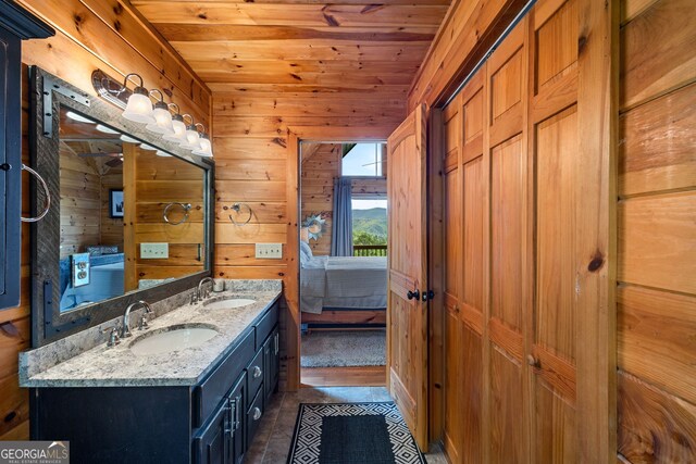 bathroom featuring wooden ceiling, wood walls, and a sink