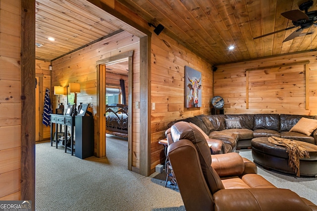 living room with wooden ceiling, a ceiling fan, carpet flooring, and wooden walls