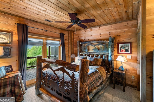 carpeted bedroom with wood walls and wooden ceiling