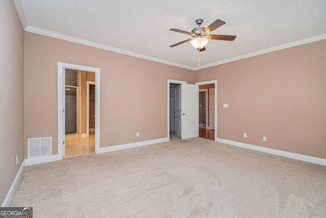 unfurnished bedroom with crown molding, light colored carpet, baseboards, a walk in closet, and a ceiling fan