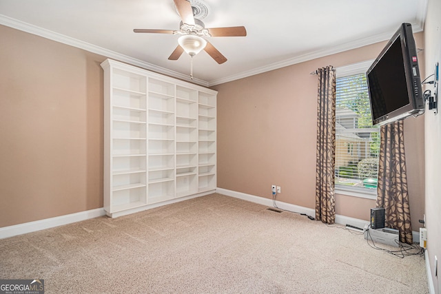 unfurnished room featuring a ceiling fan, carpet floors, crown molding, and baseboards
