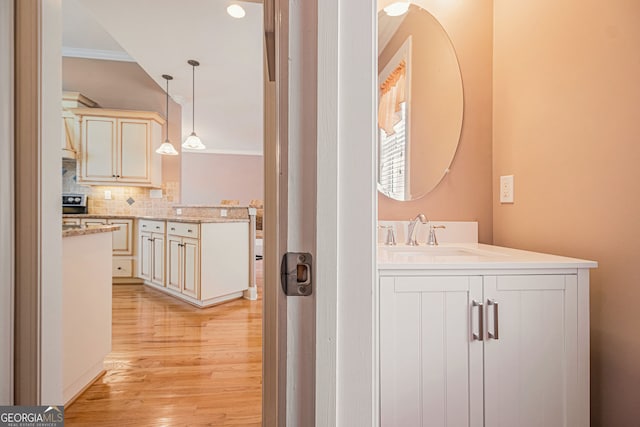 bathroom featuring ornamental molding, wood finished floors, decorative backsplash, vanity, and recessed lighting
