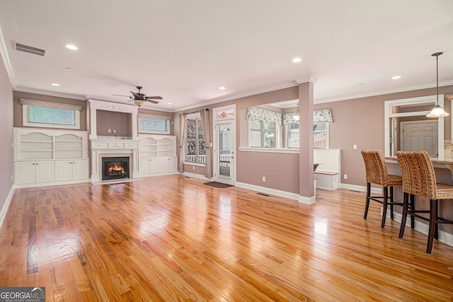 living area featuring a ceiling fan, ornamental molding, baseboards, light wood finished floors, and recessed lighting