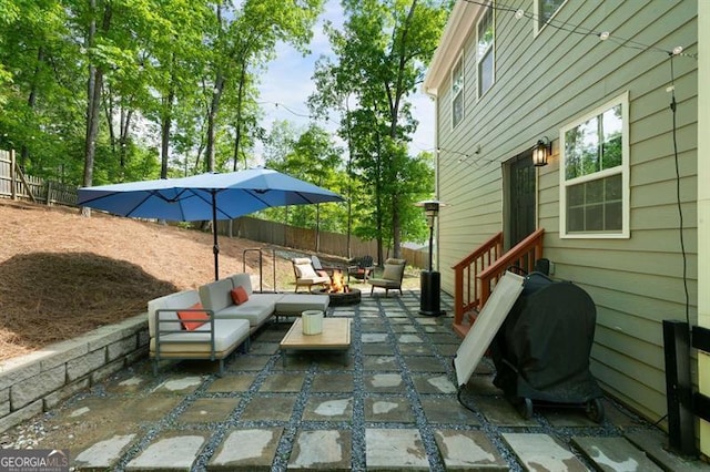 view of patio with a grill, an outdoor living space with a fire pit, and fence