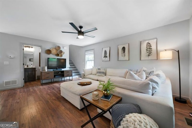 living area featuring stairs, wood finished floors, visible vents, ceiling fan, and baseboards