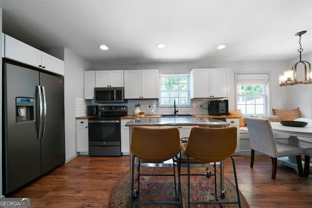 kitchen with white cabinets, stainless steel appliances, a healthy amount of sunlight, and a sink