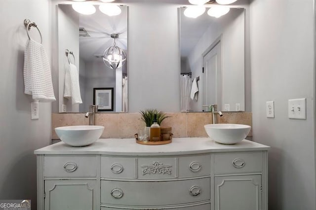 bathroom with backsplash, double vanity, and a sink