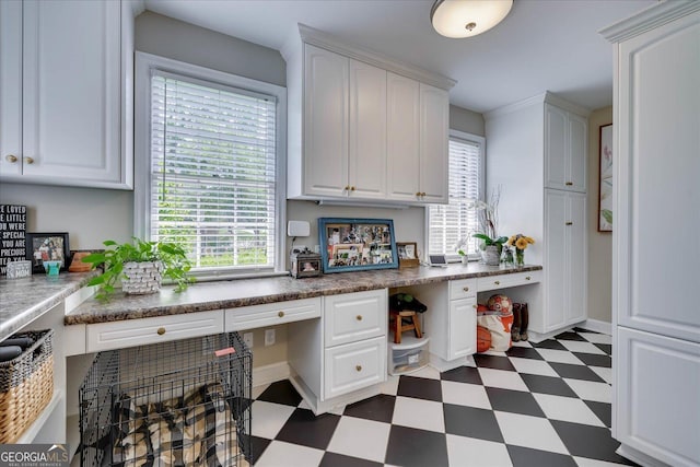 5 Prather Woods Ln, Augusta, GA 30909 - kitchen with white cabinets, dark floors, built in desk, and a wealth of natural light