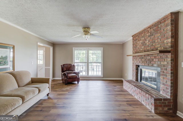 living room featuring a fireplace, wood finished floors, a textured ceiling, and ceiling fan