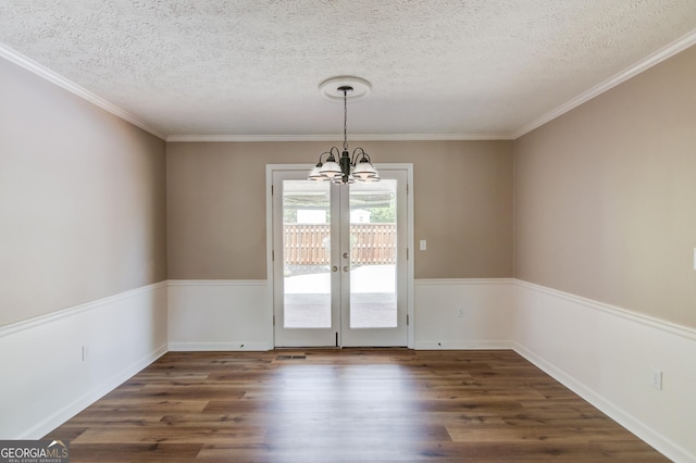 unfurnished dining area featuring french doors, a notable chandelier, wood finished floors, and a textured ceiling