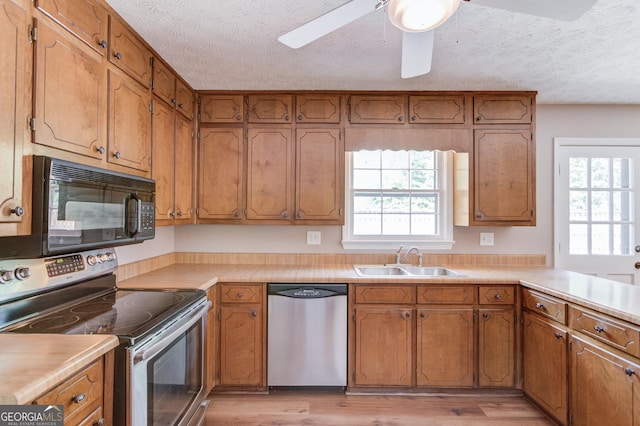 kitchen with brown cabinets, appliances with stainless steel finishes, and a sink