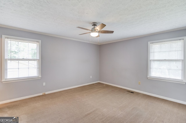 spare room featuring visible vents, a ceiling fan, baseboards, and ornamental molding