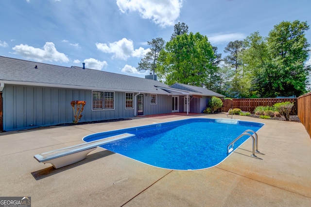 view of pool featuring a patio area, a fenced in pool, a fenced backyard, and a diving board