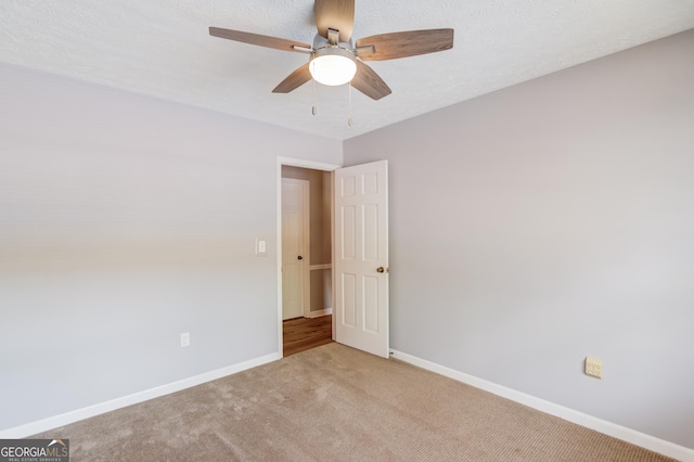 unfurnished room featuring carpet flooring, baseboards, and ceiling fan