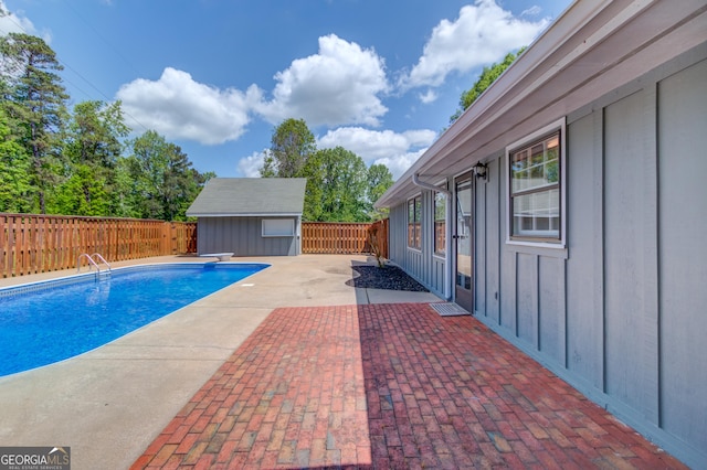 view of swimming pool with a fenced in pool, a fenced backyard, a diving board, a patio area, and an outdoor structure