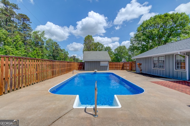 view of pool featuring a shed, a fenced backyard, an outbuilding, a patio, and a fenced in pool