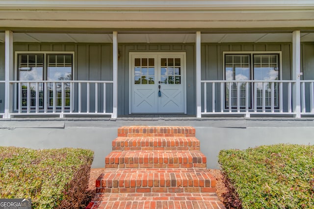 property entrance with board and batten siding and covered porch