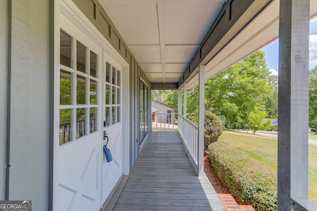 deck featuring a lawn and a porch