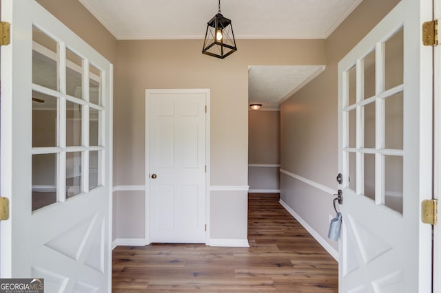 entryway with baseboards, wood finished floors, and ornamental molding
