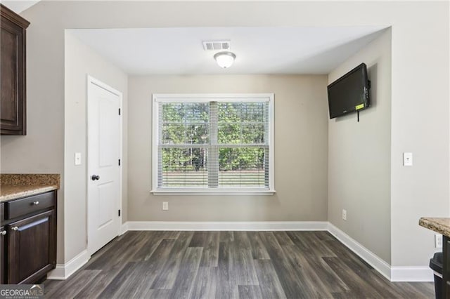unfurnished dining area with baseboards, visible vents, and dark wood-style floors