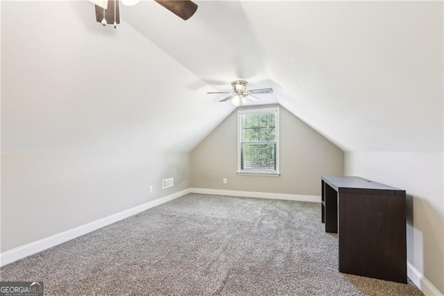 additional living space featuring visible vents, carpet flooring, baseboards, a ceiling fan, and vaulted ceiling