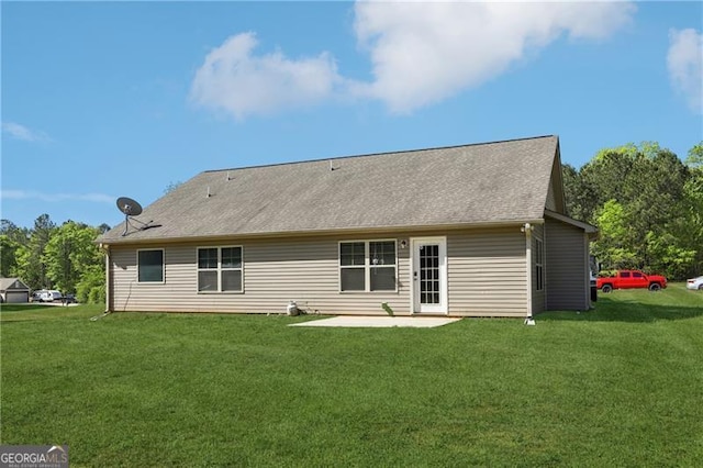 rear view of house with a lawn and a patio