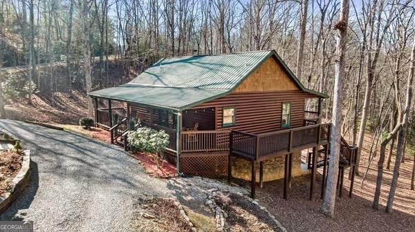 30 The Forest Rd, Blue Ridge, GA 30513 - view of front facade featuring gravel driveway, log veneer siding, a deck, and metal roof
