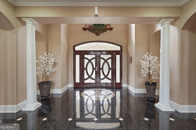 foyer entrance with granite finish floor, ornate columns, and baseboards