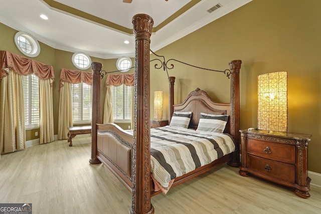 bedroom with ornamental molding, visible vents, light wood-style flooring, and multiple windows