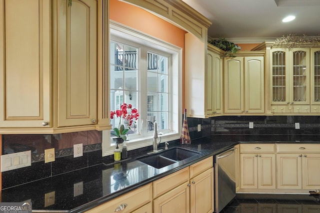 kitchen featuring backsplash, dishwasher, cream cabinets, and a sink
