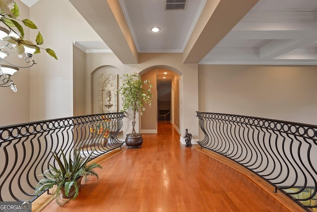 corridor featuring recessed lighting, arched walkways, wood finished floors, ornamental molding, and visible vents