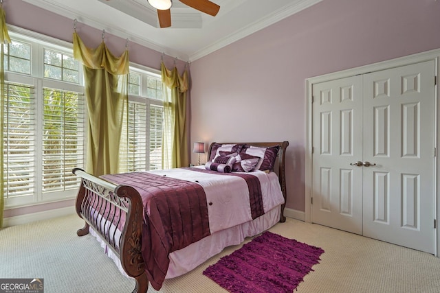 bedroom with ornamental molding, a ceiling fan, carpet floors, and a closet