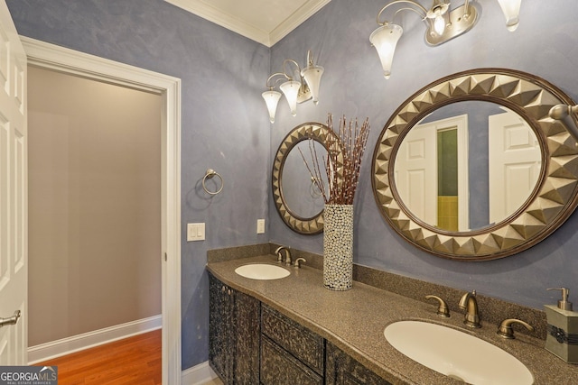 bathroom with double vanity, wood finished floors, ornamental molding, and a sink