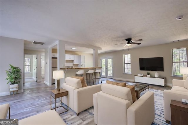 479 Lakeview Dr, Dahlonega, GA 30533 - living room featuring light wood finished floors, a textured ceiling, baseboards, visible vents, and a ceiling fan