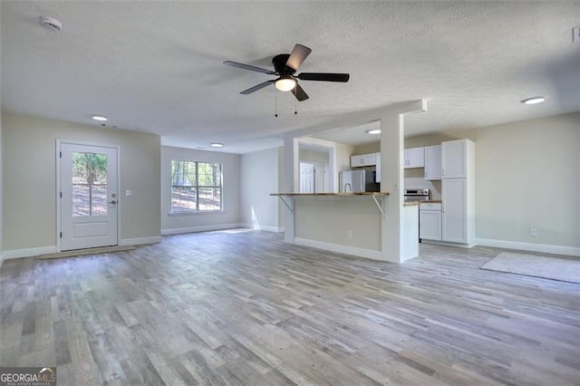 479 Lakeview Dr, Dahlonega, GA 30533 - unfurnished living room featuring ceiling fan, baseboards, a textured ceiling, and light wood finished floors
